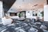 Elegant and spacious living area featuring modern light fixtures, comfortable sectional sofas, artistic decor, and a chic open kitchen.