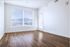 Bright, elegant room with polished wood floors, large window with scenic mountain view, and modern white walls.