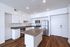 Modern kitchen with sleek stainless steel appliances and elegant white cabinetry, complemented by sophisticated hardwood flooring.
