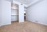 Spacious bedroom with plush carpet, ample closet space, and modern door design leading to a sleek kitchen.