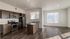 Chic open-concept kitchen with stainless steel appliances, sleek dark wood cabinets, and large windows for natural light.