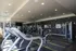 Modern fitness center with state-of-the-art equipment, treadmills, and weight machines under ambient lighting for an ultimate workout experience.
