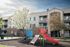 Charming apartment complex featuring a vibrant playground, blossoming trees, and welcoming balconies.