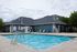 Inviting outdoor swimming pool area with modern loungers and a cozy clubhouse, perfect for relaxation and social gatherings.