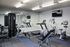 Modern gym with state-of-the-art fitness equipment including treadmill, elliptical, and weight machines in bright, spacious setting.