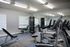 Modern fitness center with state-of-the-art exercise equipment, sleek flooring, and ample natural light from large windows.