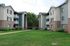 Charming apartment complex with spacious balconies, lush greenery, and inviting pathways creating a serene living environment.