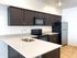 Modern kitchen with sleek dark cabinets, stainless steel appliances, and elegant countertops.
