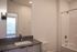 Modern bathroom with sleek sink and vanity, featuring a spacious shower and elegant lighting.