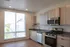 Modern kitchen with sleek appliances, generous natural light from large window, and elegant cabinetry.