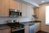 Modern kitchen with sleek stainless steel appliances, elegant wood cabinetry, and ample natural light.