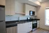 Contemporary kitchen with sleek stainless steel appliances, glossy countertops, and ample cabinet storage.