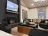 Chic living room featuring a cozy fireplace, stylish black chairs, modern art, and a sophisticated dining area with unique decor.