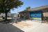 Charming apartment entrance with secure package locker and modern mailbox station surrounded by lush landscaping.