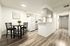 Modern kitchen-dining area with sleek cabinetry, cozy dining set, and stylish laminate flooring.