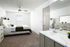 Inviting bedroom with a modern wooden bed, cozy green accents, sleek ceiling fan, and an elegant en-suite bathroom.