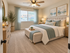 Inviting bedroom with elegant decor, featuring a plush bed, soothing color palette, and natural light from a large window.