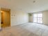 Large living area with carpet and sliding glass doors leading onto balcony  in apartment at at Westford Park apartments in Lowell, MA.