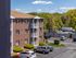 Exterior view of building with parking at Westford Park apartments in Lowell, MA.