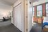 A spacious loft-style bedroom showcases soaring ceilings and expansive windows, flooding the space with natural light. | Watch Factory Lofts | Watch Factory Lofts Apartments