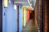 This colorful hallway features vibrant accent walls and contemporary lighting, creating a lively path to your front door. | Watch Factory Lofts | Watch Factory Lofts Apartments