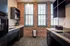 Sleek modern kitchen with quartz countertops and black cabinetry and appliances with exposed brick walls at Watch Factory Lofts apartments in Waltham, MA.