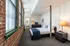White walls contrast with windowed exposed brick walls in bedrooms at Watch Factory Lofts apartments in Waltham, MA.| Watch Factory Lofts | Watch Factory Lofts Apartments