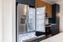 The James Apartments | Kitchen with an open stainless steel refrigerator, showing a well-organized space with adjacent dark blue and wooden cabinetry | Luxury Apartments in Haverhill MA