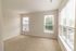 The James Apartments | Bright, spacious bedroom with beige carpet, multiple windows, and a view of the outside greenery | Luxury Apartments in Haverhill MA