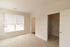 The James Apartments | Bright bedroom with beige carpet, large windows, and an open closet with wire shelving  | Luxury Apartments in Haverhill MA