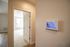 The James Apartments | Smart home ADT system panel mounted on the wall near a doorway, leading to a carpeted bedroom with natural light | Luxury Apartments in Haverhill MA