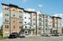 The James Apartments | Modern five-story apartment building with stone, beige, and white exterior, featuring a variety of windows and balconies. Several cars are parked in front of the building | Luxury Apartments Haverhill MA