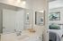 The James Apartments | Modern bathroom featuring a white vanity with a sink and mirror, with a view into the bedroom in the background, decorated with abstract wall art. | Luxury Apartments Haverhill MA