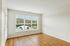 The James Apartments | Unfurnished room with hardwood flooring, large windows, and a scenic view of green hills and rooftops. | Luxury Apartments Haverhill MA