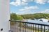 The James Apartments | Private balcony with a railing, offering a scenic view of green trees, rooftops, and a nearby sports field. | Luxury Apartments Haverhill MA