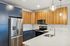 The James Apartments | Modern kitchen at 895 Boston Rd featuring wood cabinetry, stainless steel appliances, and a central island with a built-in sink. | Luxury Apartments Haverhill MA