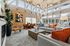 Spacious living room with high ceilings, large windows, and stylish decor with comfortable seating and a dining area.
