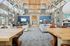 Spacious lounge with modern furnishings, high ceilings, and large windows for natural light.