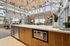 Bright and airy loft with modern decor, featuring a spacious kitchen island and cozy seating area with high ceilings and large windows.