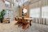 Elegant dining area with modern wooden table, stylish brown chairs, large window, and decorative elements.