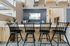 Stylish kitchen with black high-back chairs, sleek countertops, and artistic wall decor in a contemporary setting.