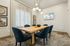 Chic dining room with a wooden table, plush blue chairs, and modern pendant lighting.