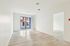 Bright and airy room with large windows and sleek hardwood floors, offering a modern, spacious feel.