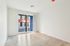 Bright and airy room with sleek flooring and large windows offering a modern urban view.