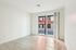 Bright and modern apartment with elegant hardwood floors, large window, and serene white walls.