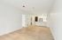 Bright, modern open-plan living area with sleek kitchen featuring stainless steel appliances and elegant wood flooring.