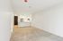 Bright open-concept living area with a modern kitchen, highlighting sleek white cabinetry and stainless steel appliances, perfect for entertaining.