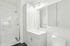 Elegant bathroom featuring modern vanity with ample storage, sleek fixtures, and a spacious glass-enclosed shower.
