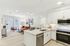 Modern open-plan apartment with a sleek kitchen, cozy living area, and natural light from large windows, ideal for stylish urban living.