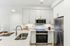 Modern kitchen with sleek stainless steel appliances, ample white cabinetry, and a stylish quartz countertop equipped with a sink.
